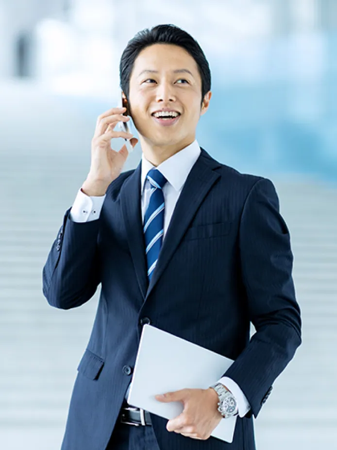 外出先で電話対応をするスーツ姿の男性社員の写真